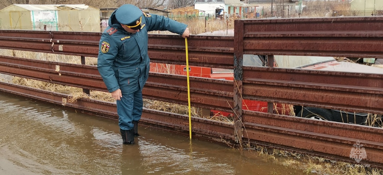 Сотрудник МЧС измеряет глубину воды во время паводка