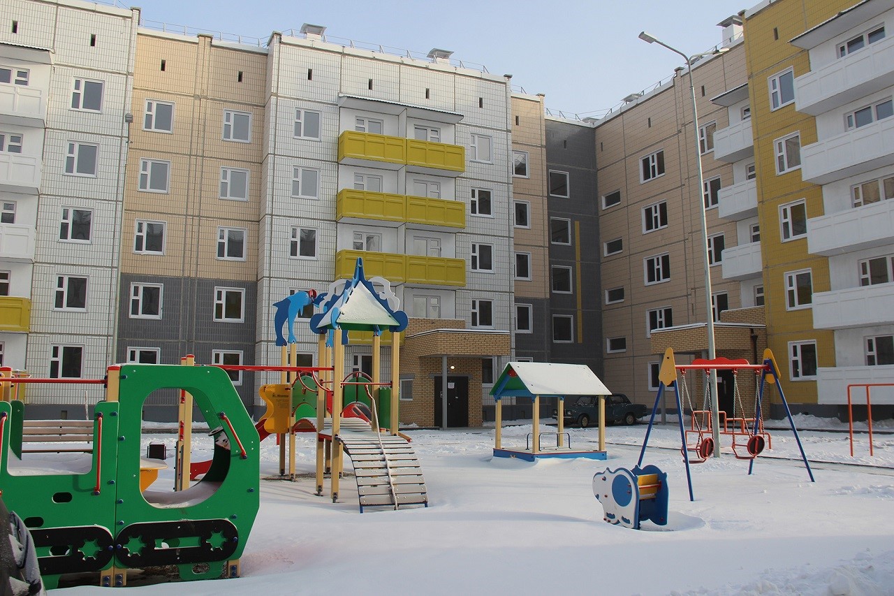 дом с детской площадкой зимой